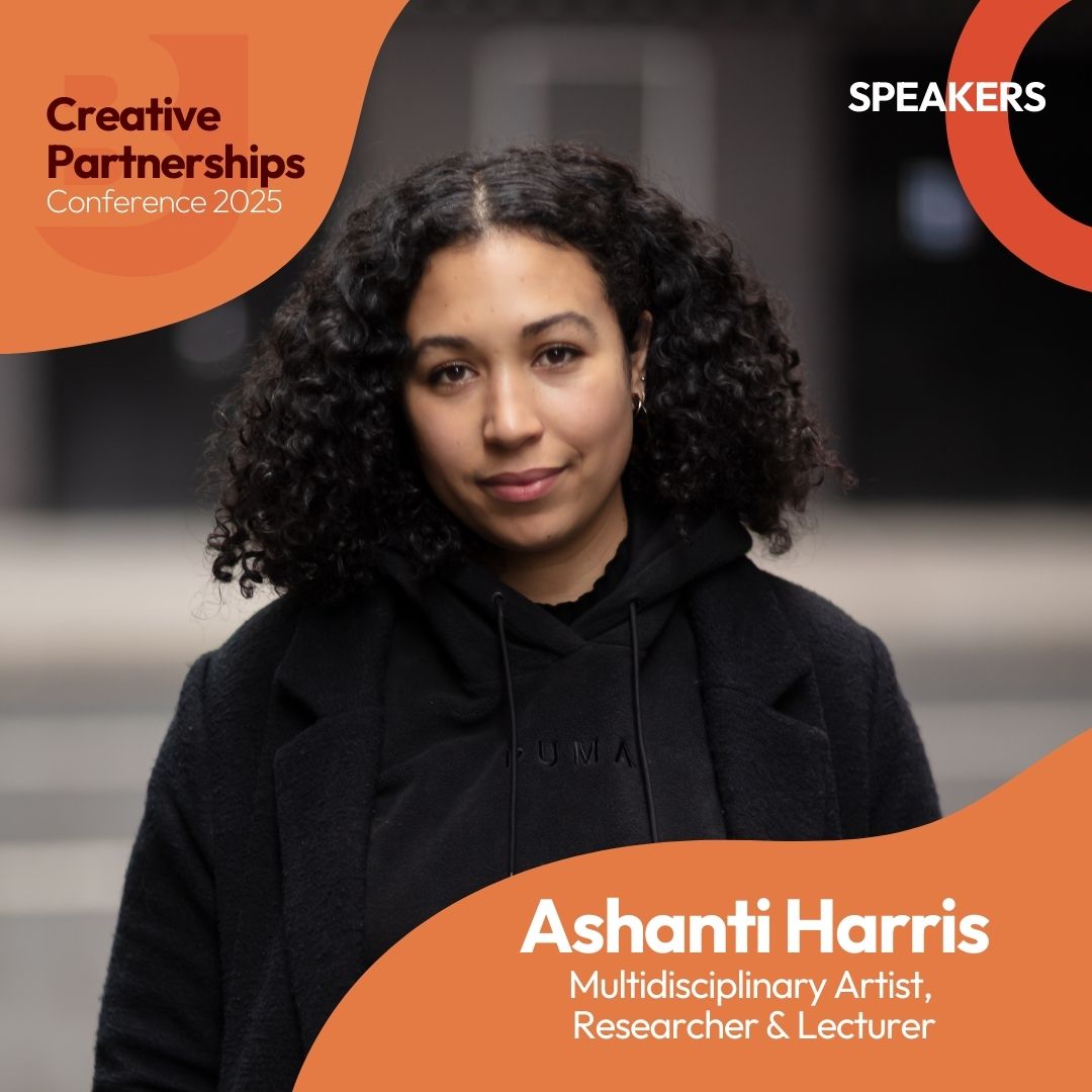 A woman with black curly hair looking at the camera. She is standing outside and is wearing a black hoodie and a black coat. Text reads: Creative Partnerships Conference 2025. Speakers. Ashanti Harris. Multidisciplinary Artist, Researcher and Lecturer.